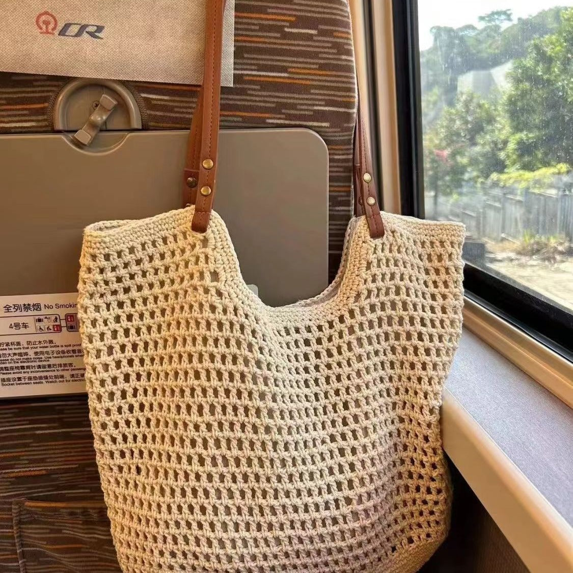 Grand ou petit sac féminin en coton tressé, au style élégant et en filet, porté à l’épaule.